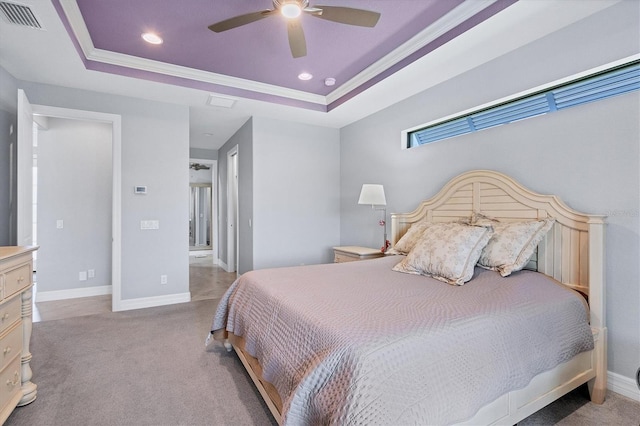 carpeted bedroom with ceiling fan and a tray ceiling