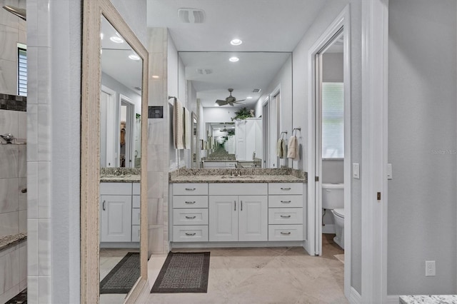 bathroom featuring toilet, vanity with extensive cabinet space, tile floors, and plenty of natural light