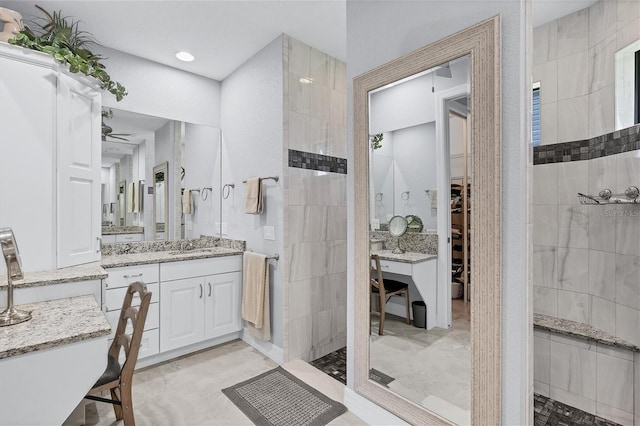 bathroom featuring a tile shower, tile flooring, ceiling fan, and tile walls