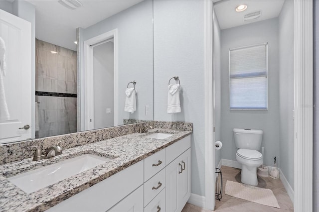 bathroom featuring toilet, tile floors, dual sinks, and large vanity