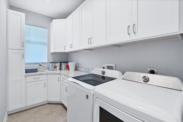 clothes washing area featuring hookup for an electric dryer, light tile floors, hookup for a washing machine, cabinets, and separate washer and dryer