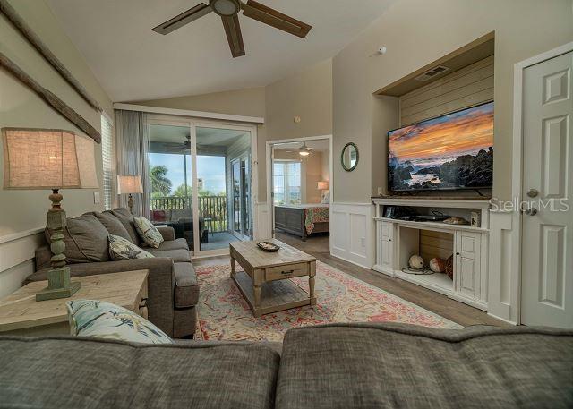 living room featuring lofted ceiling, ceiling fan, and dark hardwood / wood-style floors