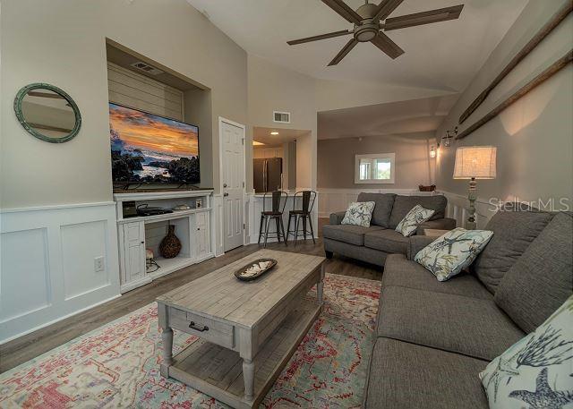 living room with lofted ceiling, ceiling fan, and dark hardwood / wood-style flooring