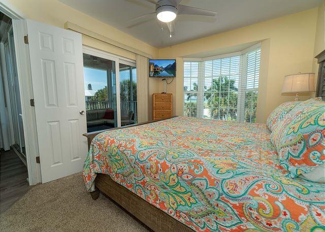 bedroom featuring access to exterior, ceiling fan, and wood-type flooring