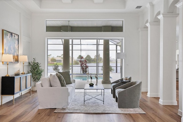 living room featuring a healthy amount of sunlight, a high ceiling, and light hardwood / wood-style flooring