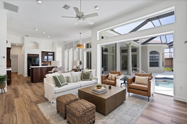 sunroom featuring decorative columns, ceiling fan, a skylight, and sink