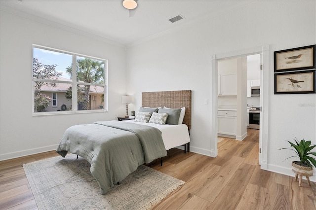 bedroom with light hardwood / wood-style flooring and crown molding