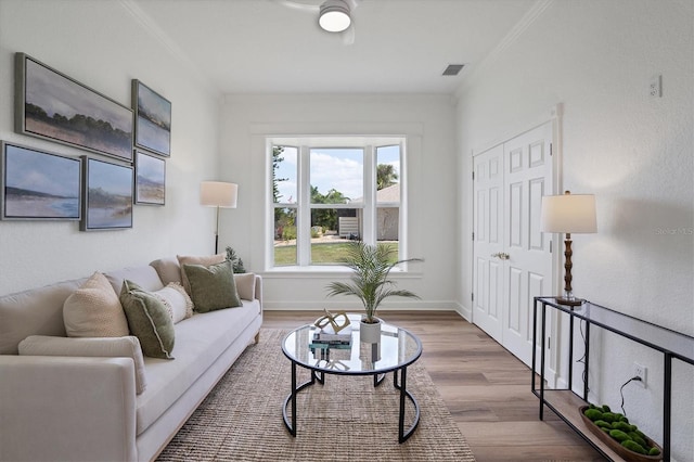 living room with crown molding and hardwood / wood-style flooring