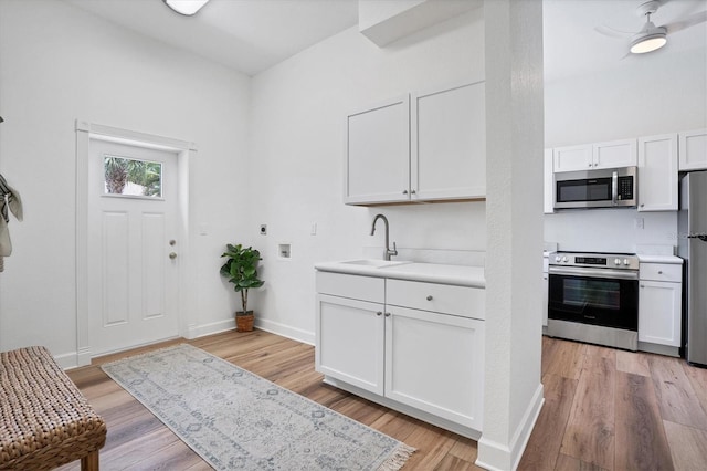 foyer entrance featuring light hardwood / wood-style floors, ceiling fan, and sink