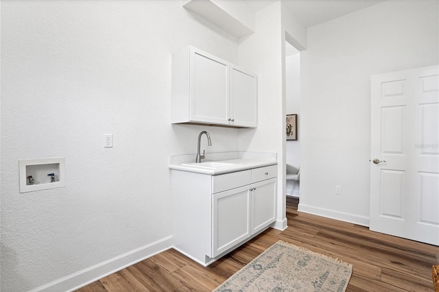 washroom featuring sink, cabinets, hardwood / wood-style flooring, and hookup for a washing machine