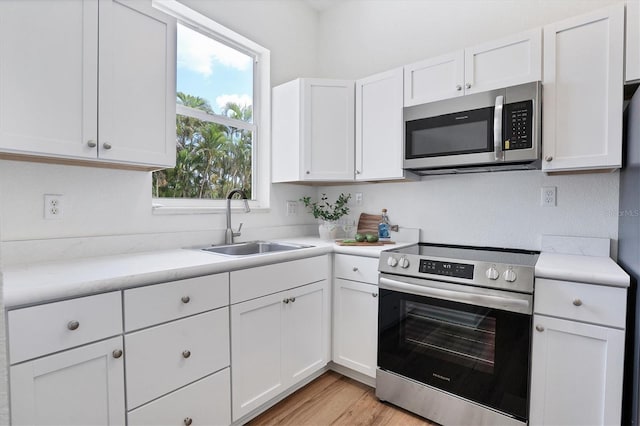 kitchen featuring white cabinetry, light wood-type flooring, sink, and stainless steel appliances