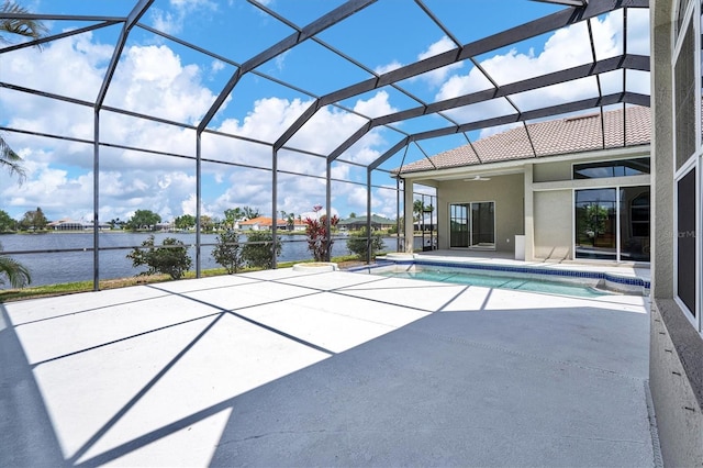 view of pool featuring a patio area, glass enclosure, and a water view