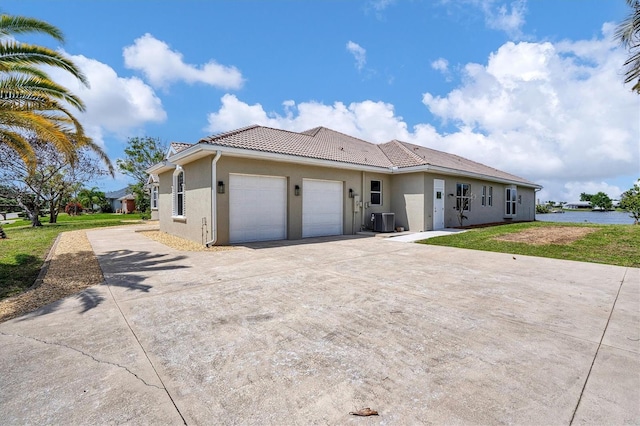 view of front facade with a front lawn, a garage, and central AC unit