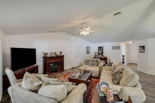 living room with lofted ceiling, ceiling fan, and dark hardwood / wood-style flooring