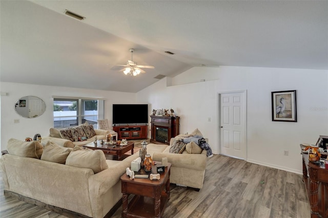 living room with hardwood / wood-style floors, vaulted ceiling, and ceiling fan