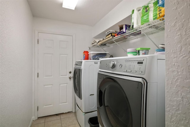 clothes washing area featuring light tile flooring and washing machine and dryer