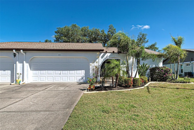 ranch-style house featuring a front yard, a garage, and central air condition unit