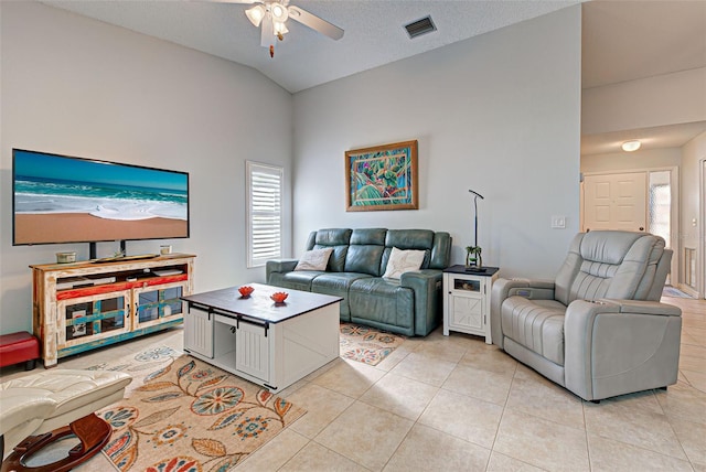 tiled living room with lofted ceiling, ceiling fan, and a textured ceiling