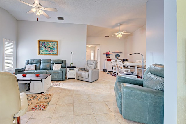 tiled living room with ceiling fan and a textured ceiling