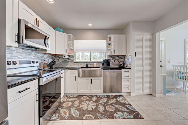 kitchen with backsplash, white cabinetry, appliances with stainless steel finishes, and sink