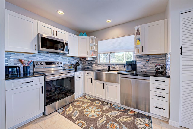 kitchen with white cabinets, tasteful backsplash, stainless steel appliances, and sink