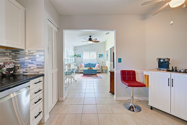 kitchen featuring lofted ceiling, ceiling fan, white cabinets, dishwasher, and tasteful backsplash