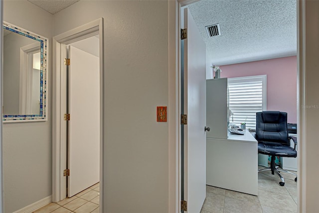 office area with a textured ceiling and light tile floors