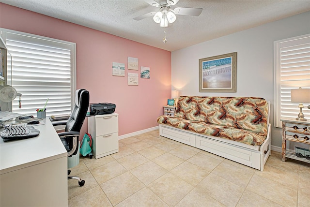 tiled office space with a textured ceiling and ceiling fan