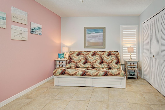 tiled bedroom featuring a closet and a textured ceiling