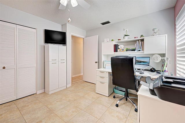 home office with light tile flooring, ceiling fan, and a textured ceiling