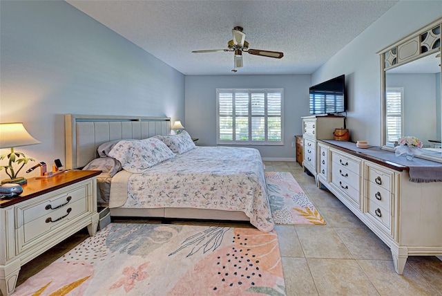 tiled bedroom featuring ceiling fan and a textured ceiling