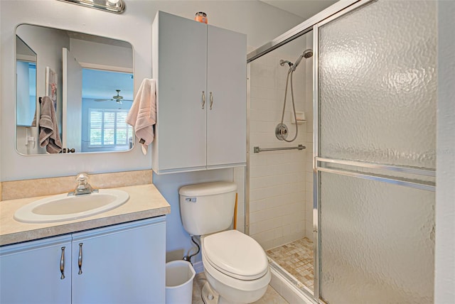 bathroom with walk in shower, toilet, ceiling fan, tile floors, and vanity