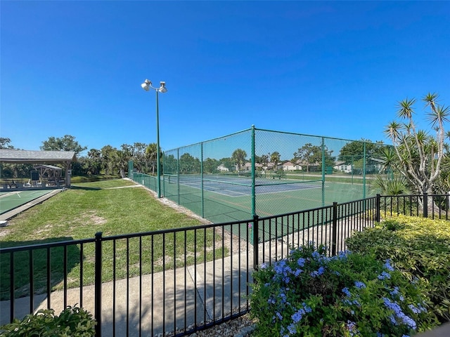 view of sport court with a lawn