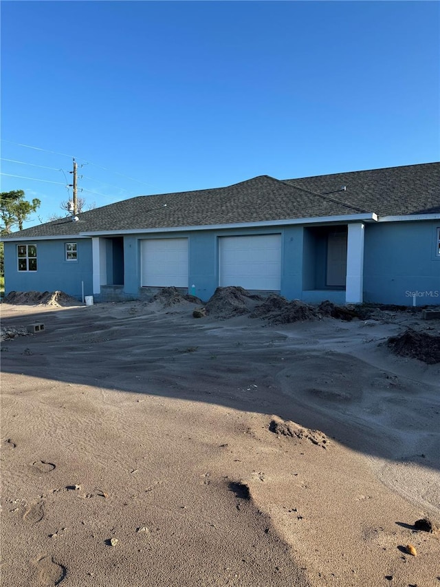 view of front of home with a garage and stucco siding