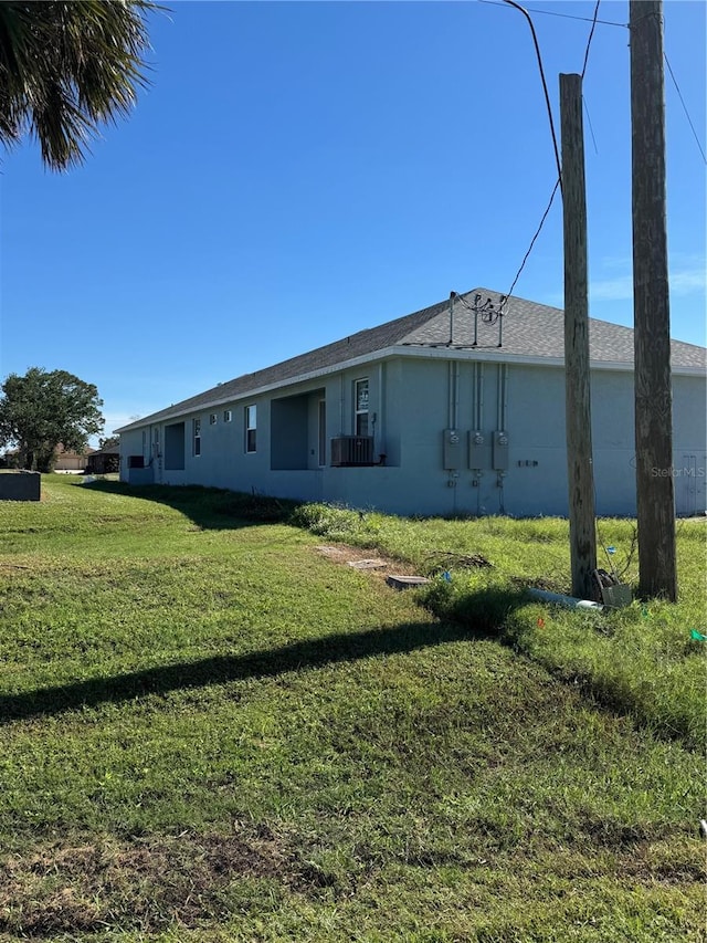 back of property featuring a lawn and stucco siding