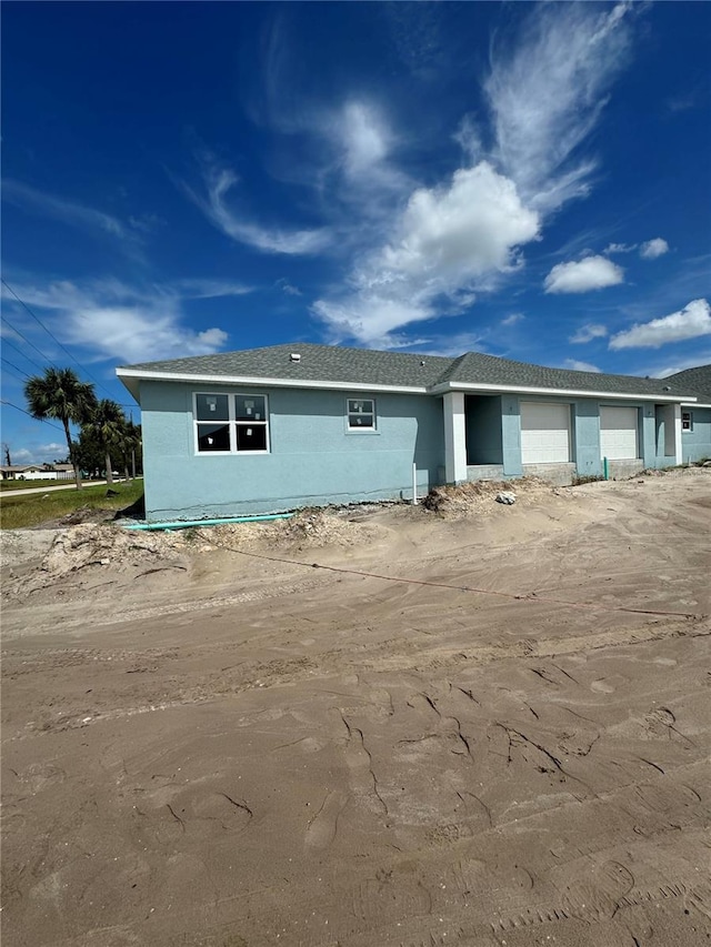 view of front of home with a garage and stucco siding