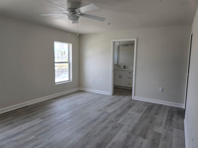 unfurnished bedroom with ensuite bathroom, ceiling fan, baseboards, and wood finished floors