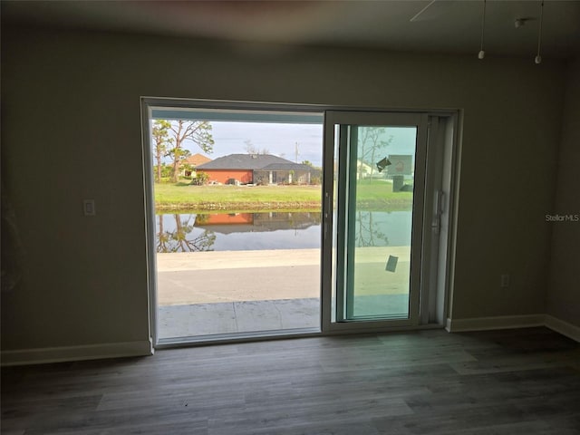 entryway featuring a water view, wood finished floors, and baseboards