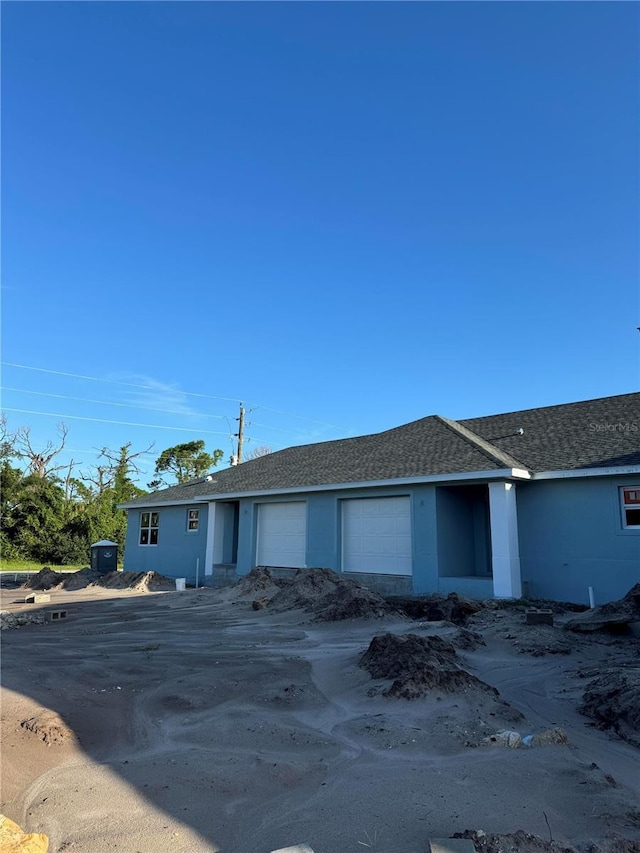 single story home with a garage and stucco siding