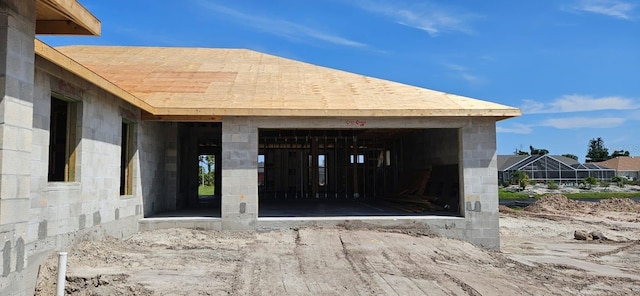 view of exterior entry with concrete block siding and a detached garage