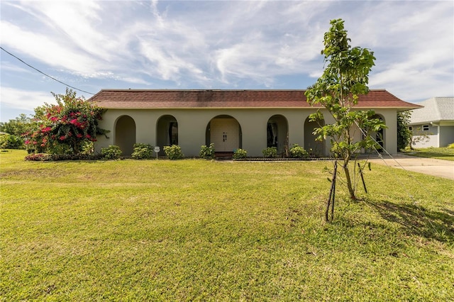 mediterranean / spanish-style house featuring a front lawn and a garage