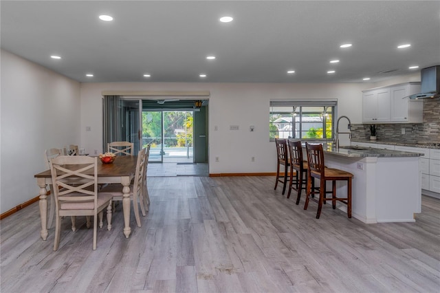 dining area featuring a healthy amount of sunlight, sink, and light wood-type flooring