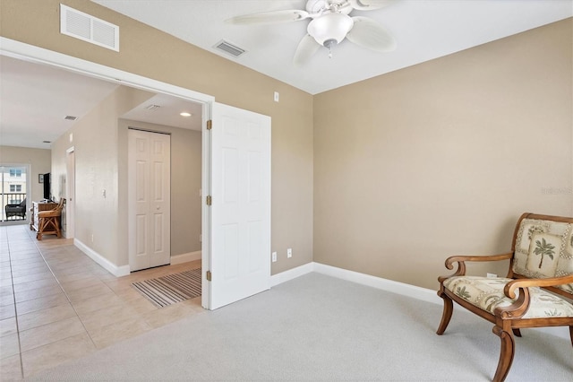 living area with light tile floors and ceiling fan