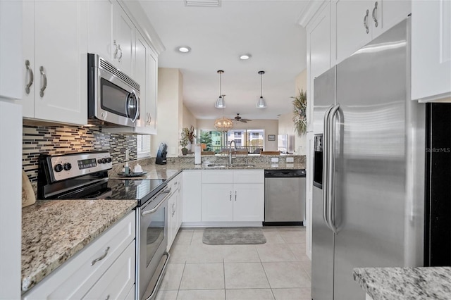 kitchen with white cabinetry, backsplash, appliances with stainless steel finishes, sink, and pendant lighting