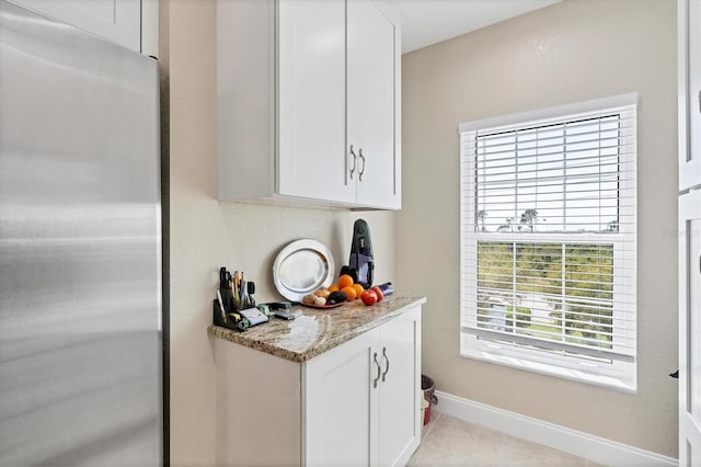 kitchen with white cabinets and stainless steel refrigerator