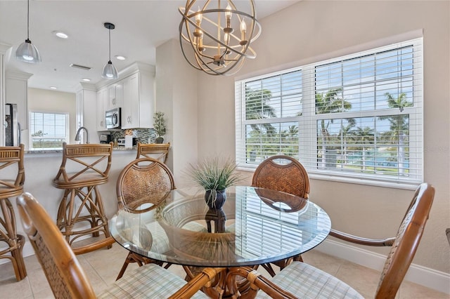 tiled dining area featuring an inviting chandelier and sink