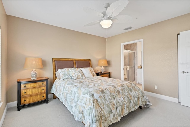 bedroom with light colored carpet, ensuite bath, and ceiling fan