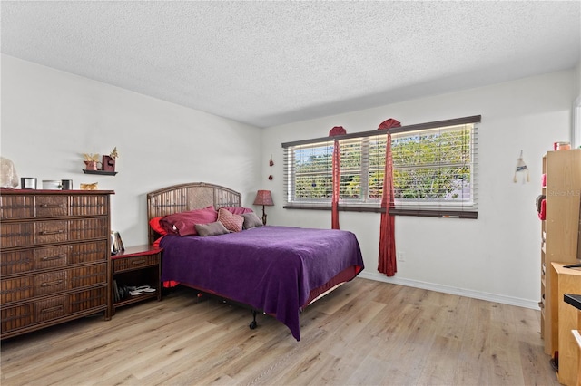 bedroom with light hardwood / wood-style flooring and a textured ceiling