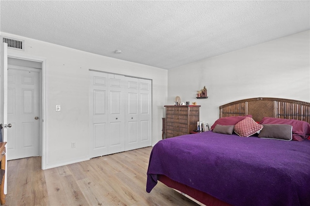 bedroom featuring a textured ceiling, a closet, and light wood-type flooring