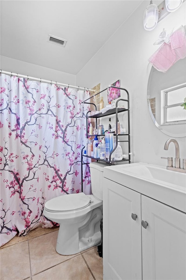 bathroom featuring vanity, tile patterned flooring, toilet, and walk in shower